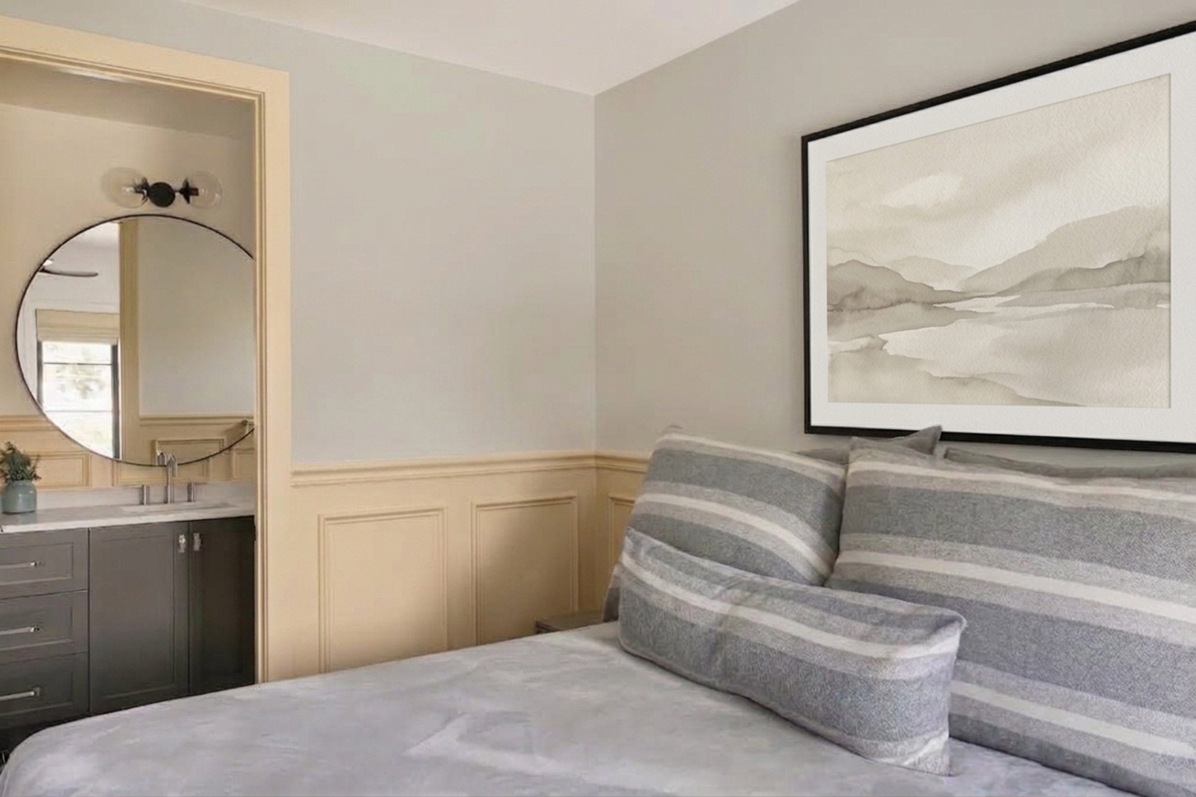 Bed corner with a glimpse into the ensuite through the open door.